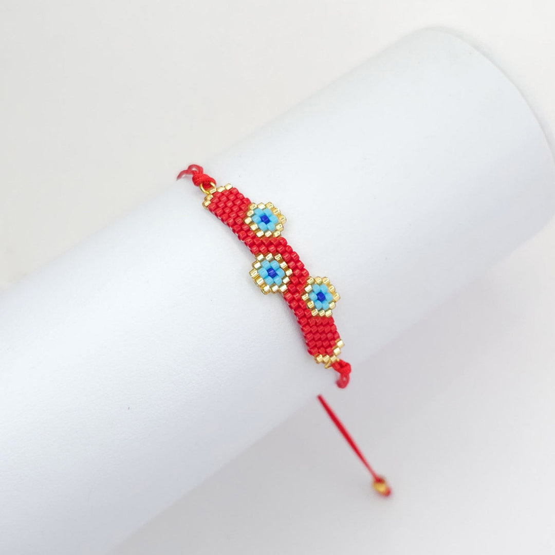 Pulsera tejida roja de 3 ojos